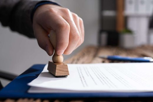 Una persona está sellando un documento con un sello de madera.