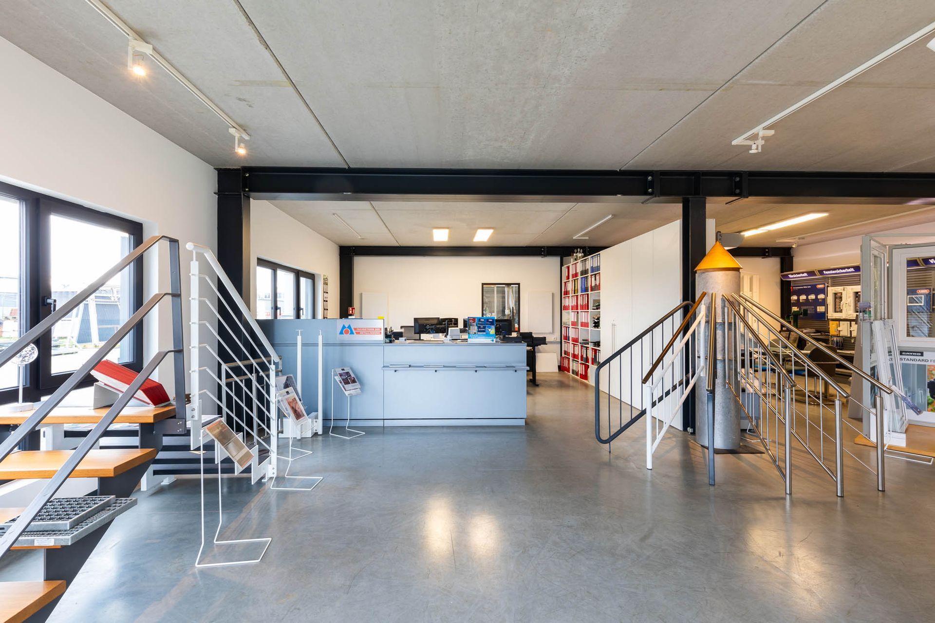 Ein großer Raum mit Treppe und einer Theke in der Mitte.