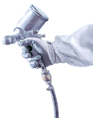 Main tenant un pistolet à peinture, portant un gant et un vêtement de protection.