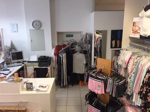 Ein Laden voller Kleidung und einer Uhr an der Wand