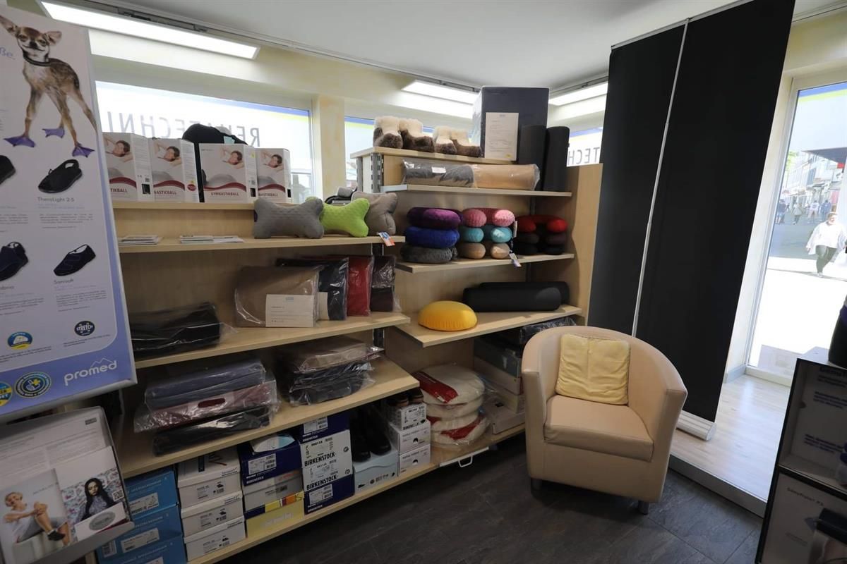 In einem Laden steht ein Stuhl, umgeben von Regalen und Kisten.