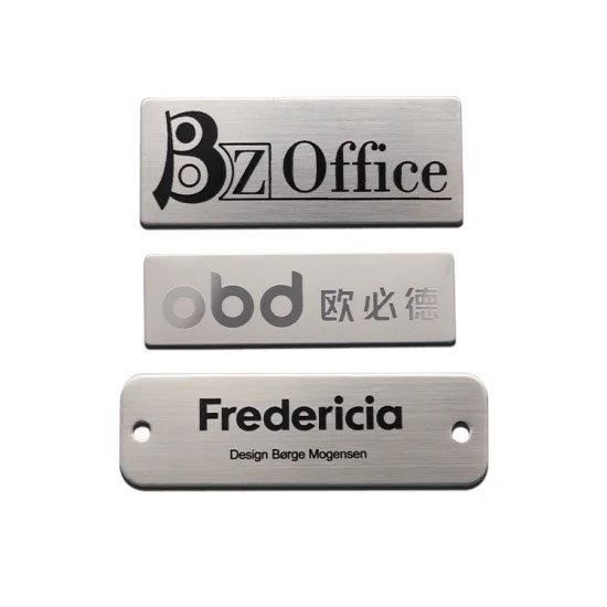 Tres placas metálicas para puertas apiladas verticalmente con texto en negro y gris.