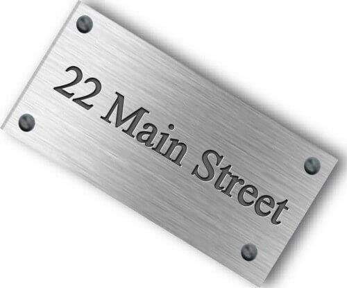 Placa plateada con la dirección “22 Main Street” con letras negras y cuatro tornillos.