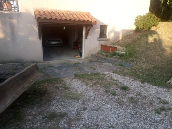 Chantier de construction avec des blocs de béton devant un bâtiment blanc, sous un ciel bleu.