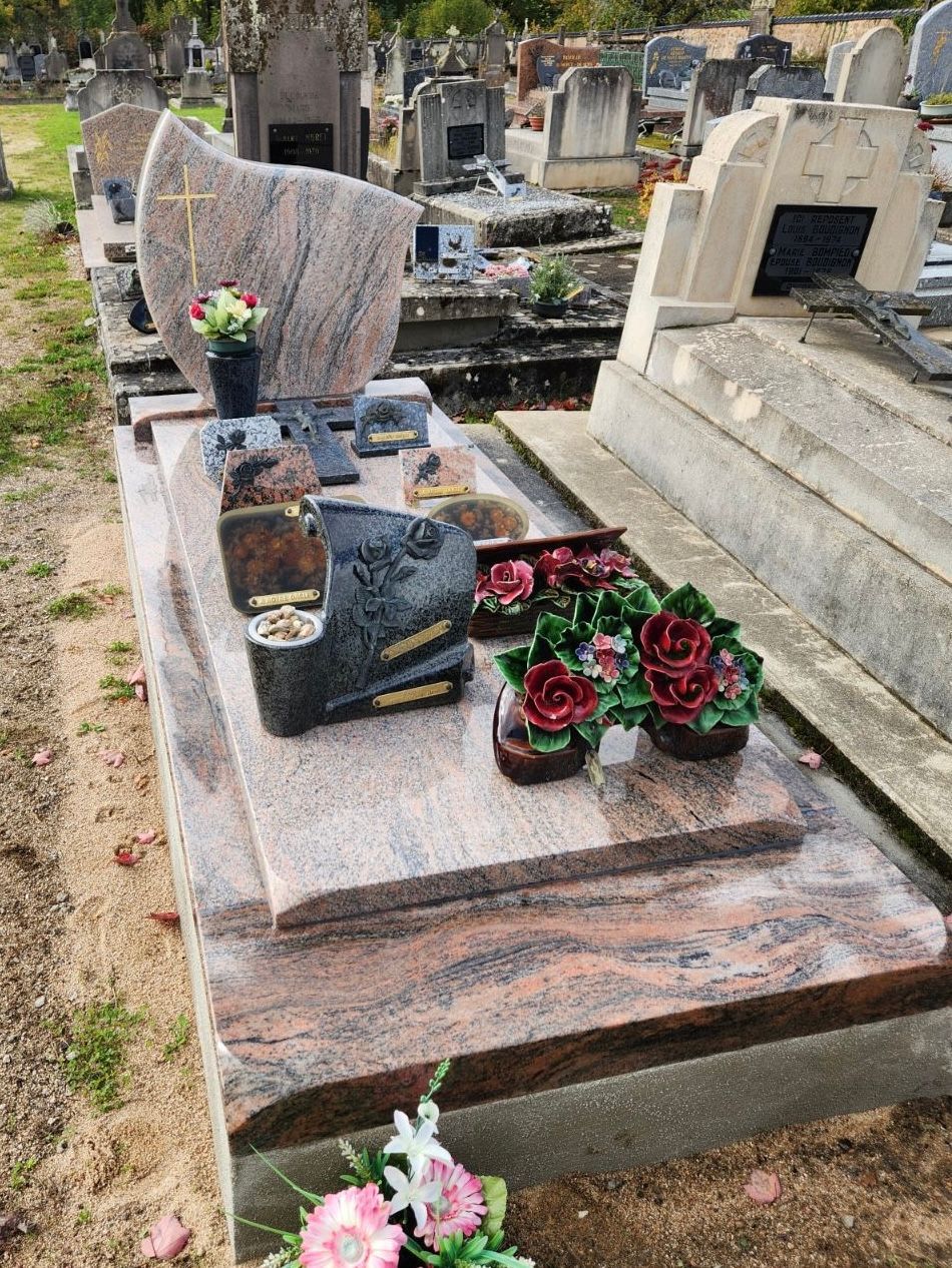 Sépulture avec stèle en granit et articles funéraires, dans un cimetière.