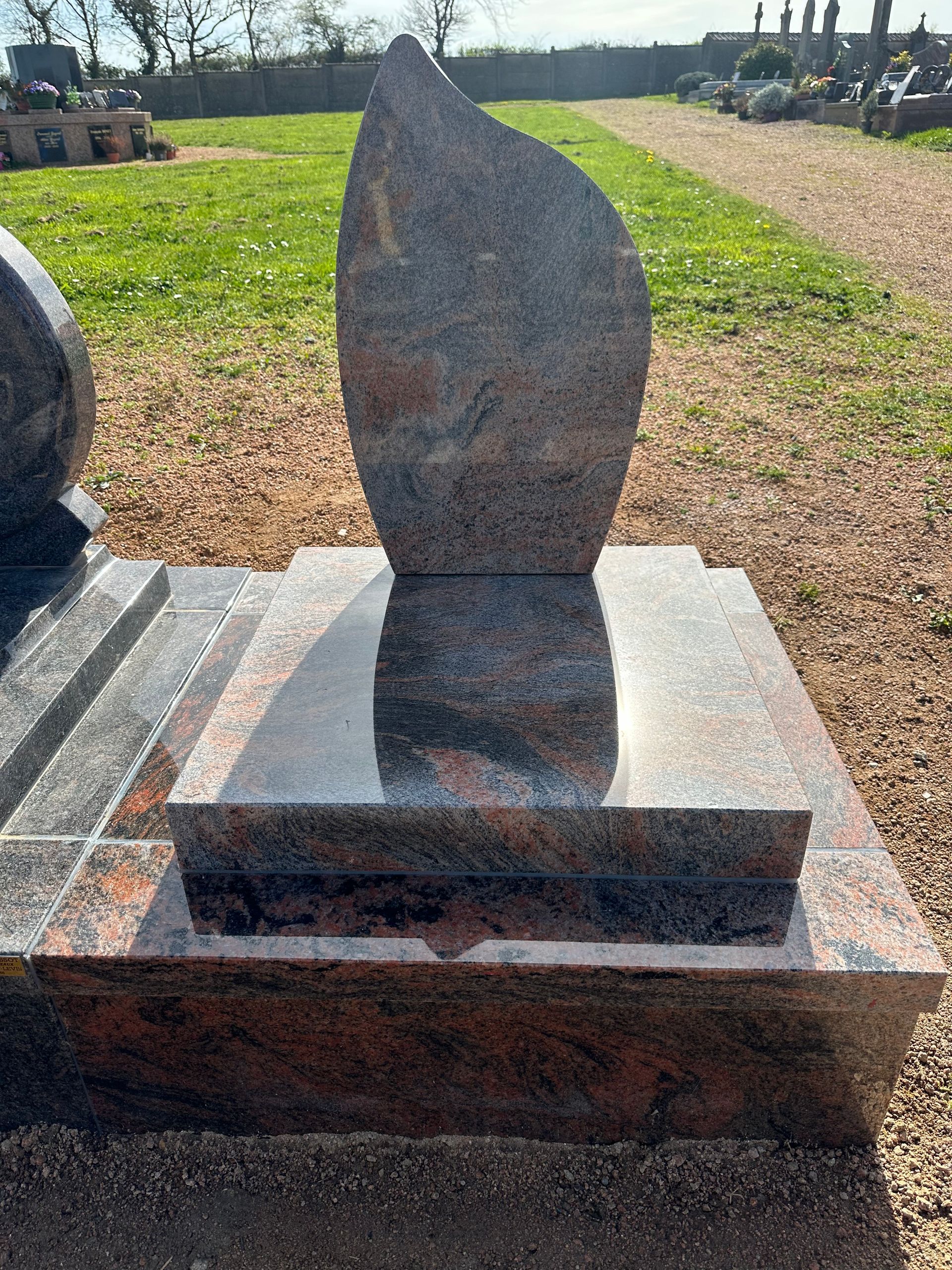 Monument cinéraire en granit gris et marron.
