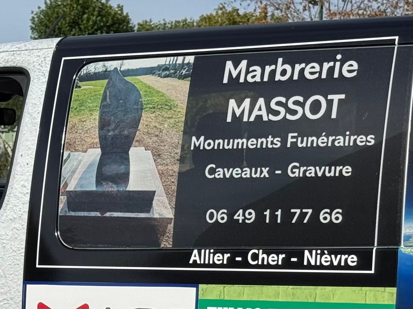 Un camion affichant les coordonnées et prestations de la Marbrerie MASSOT.