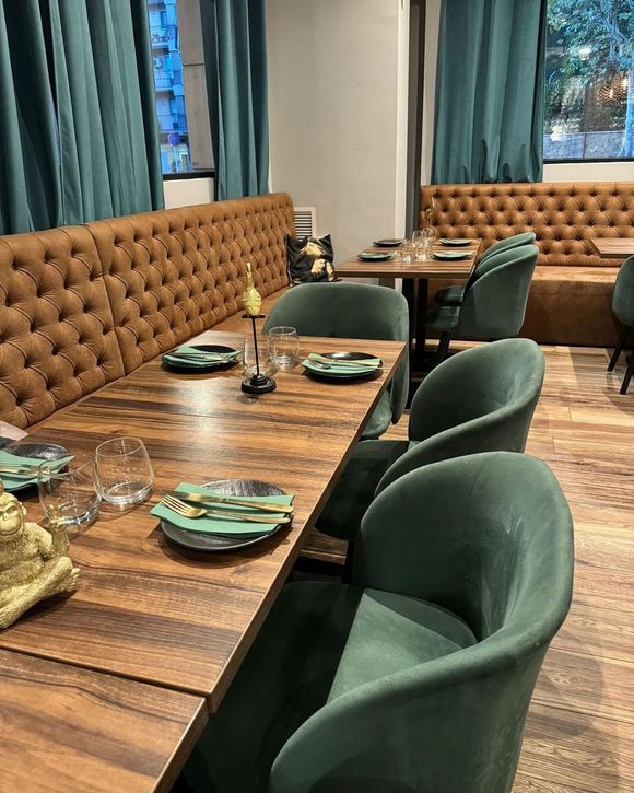 Un restaurante con mesas y sillas y platos en ellas.