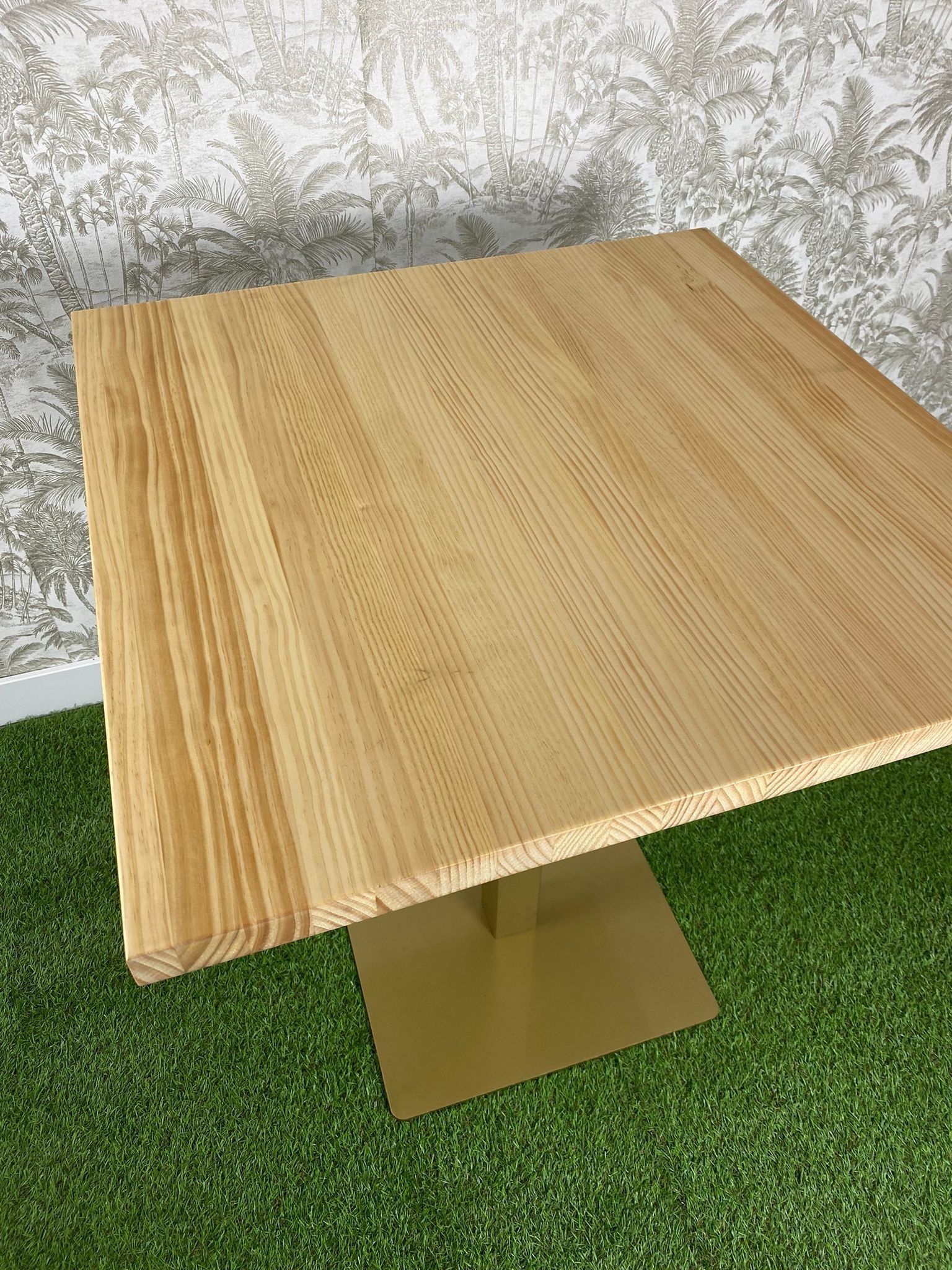 Una mesa de madera está colocada encima de una alfombra verde.