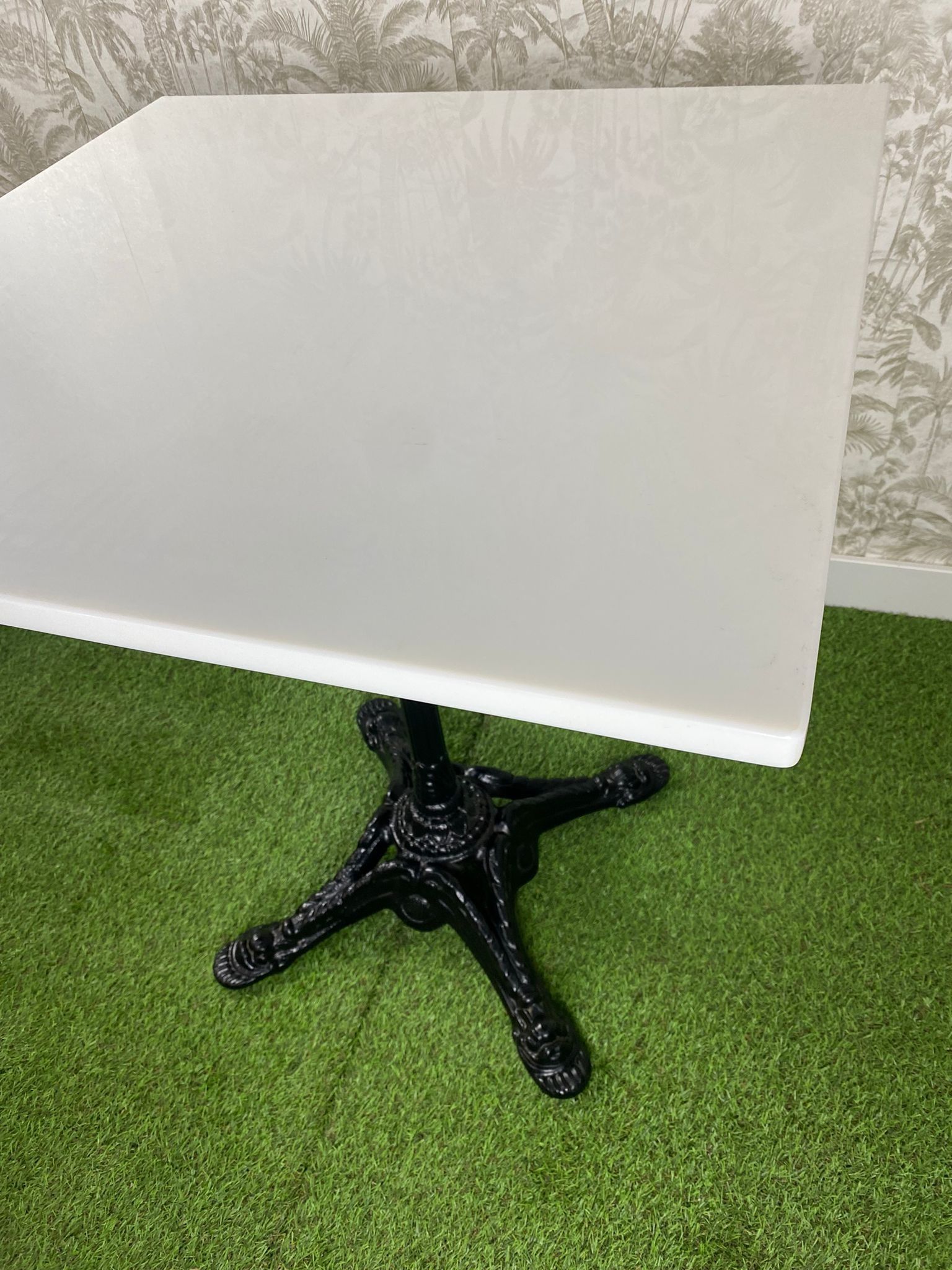 Una mesa blanca con una base negra sobre un fondo blanco