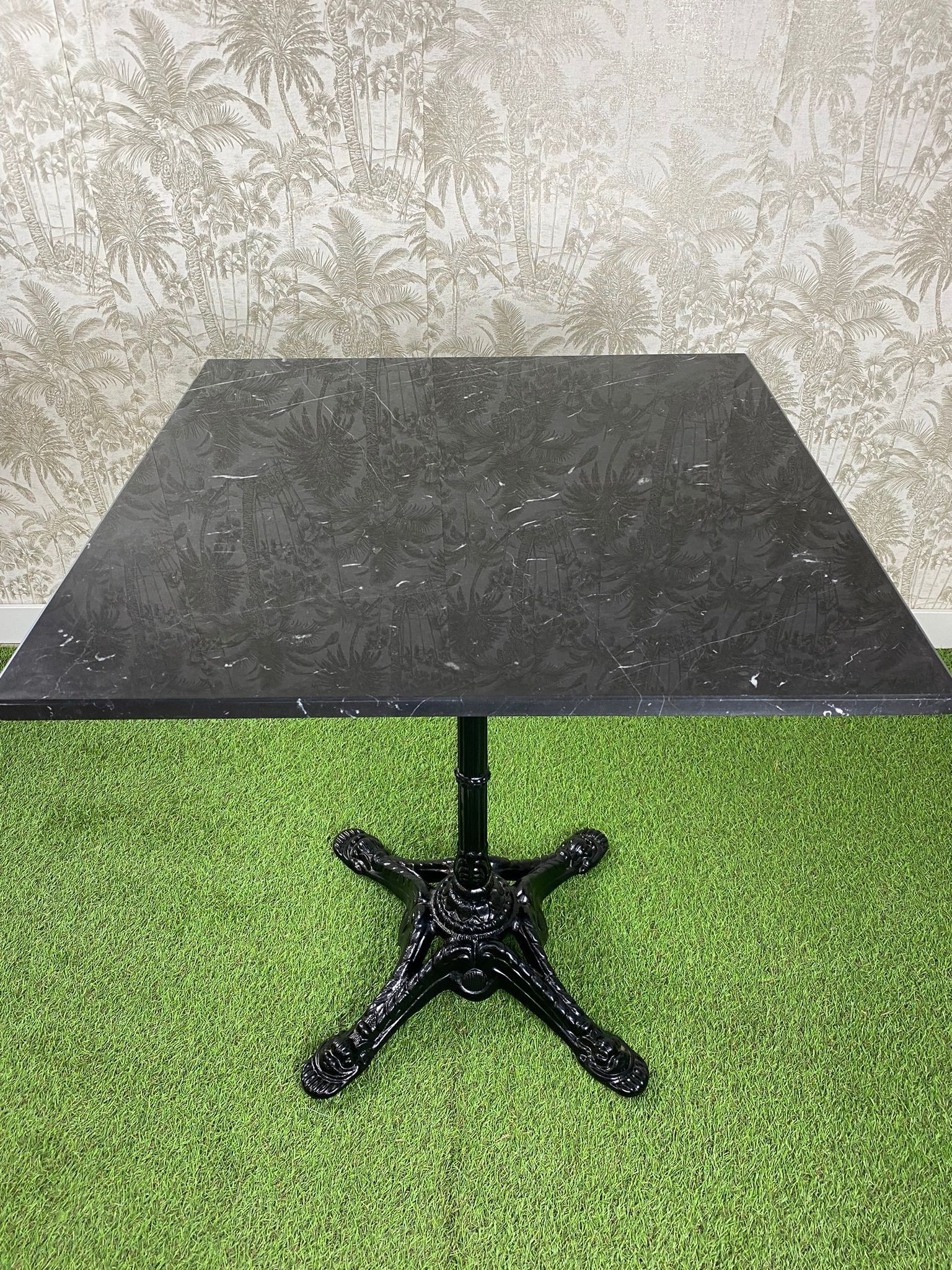 Una mesa negra está colocada encima de una alfombra verde.