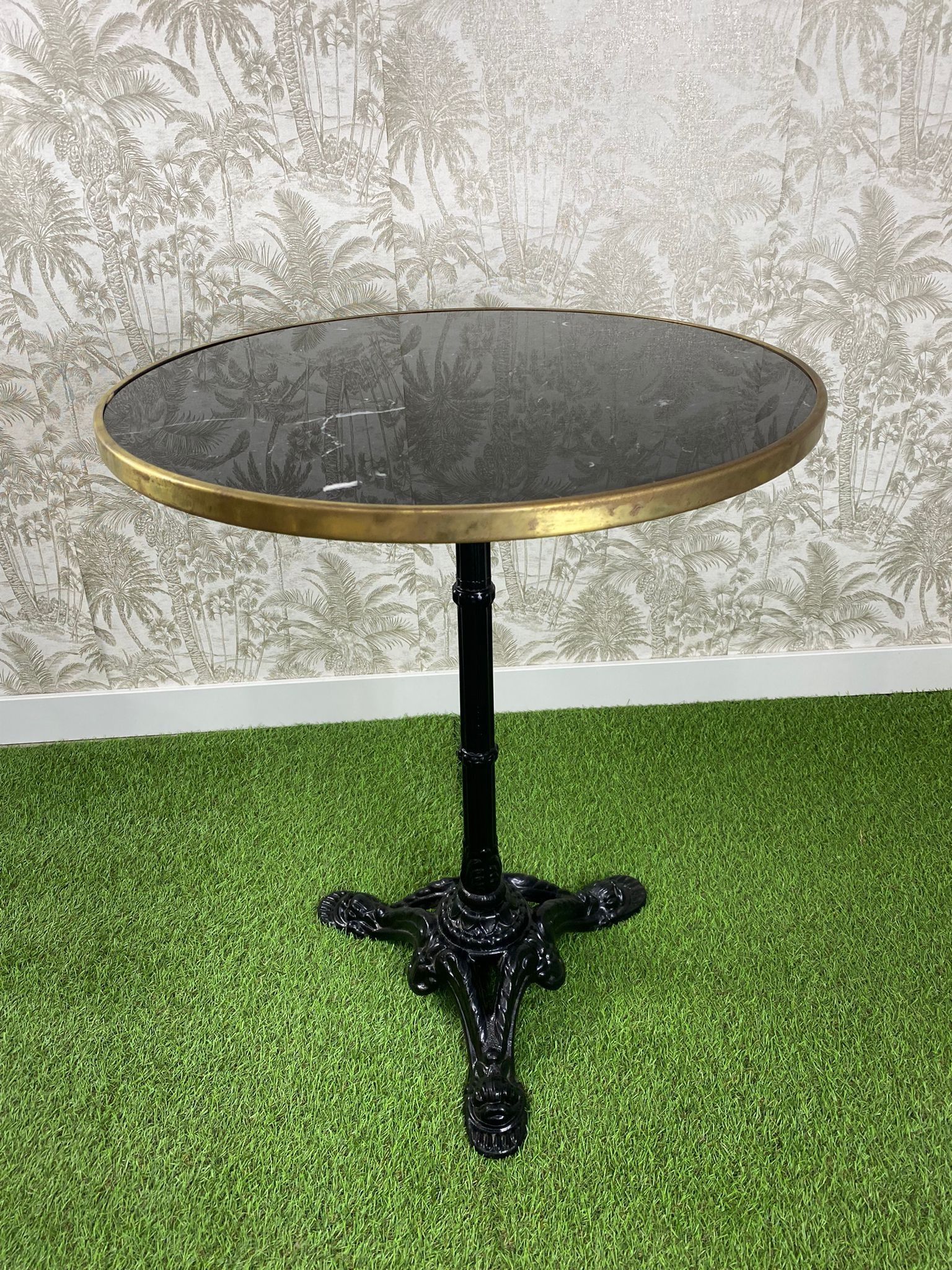 Una pequeña mesa está colocada encima de una exuberante alfombra verde.