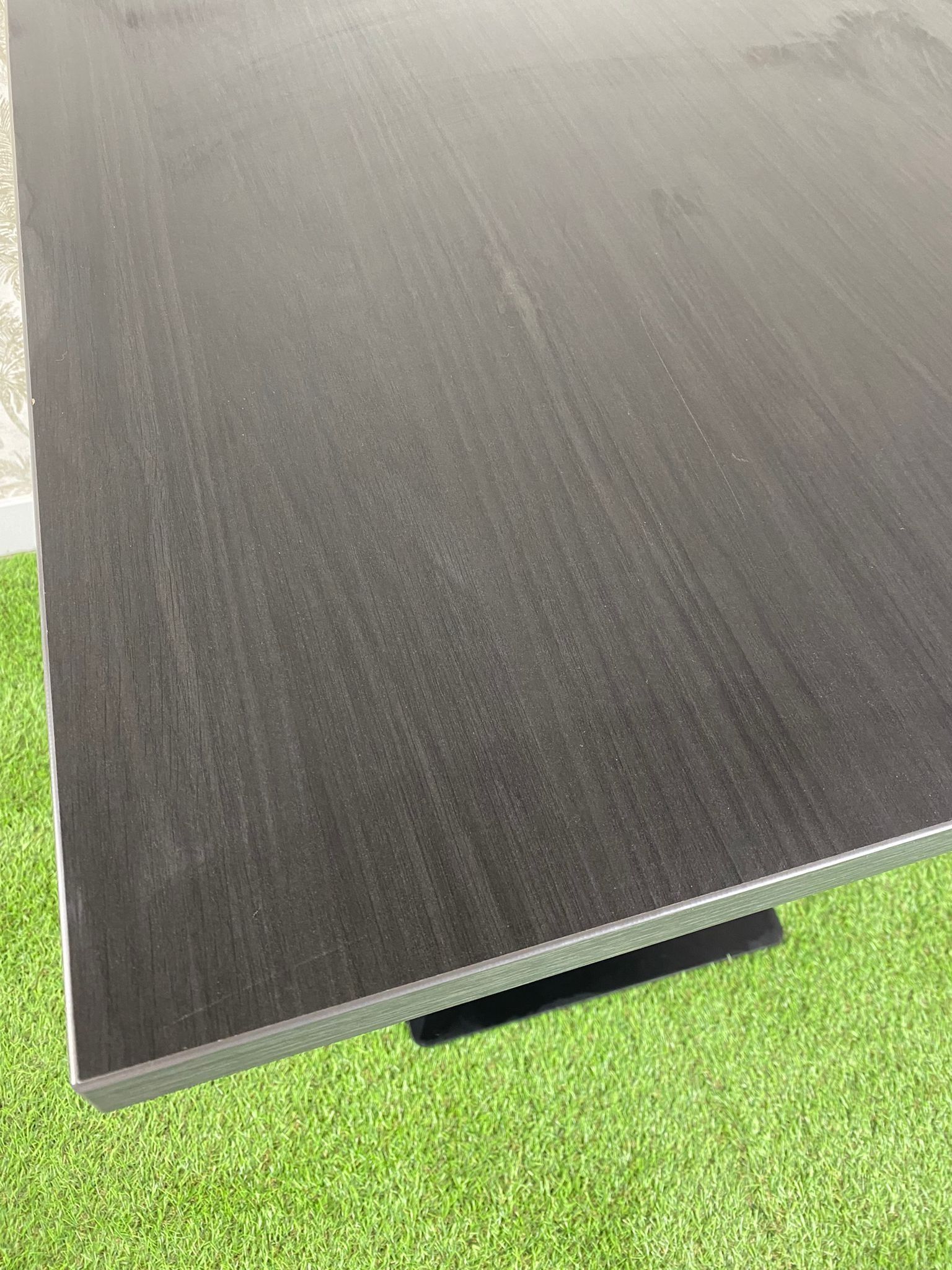 Una mesa negra está colocada encima de una alfombra verde.