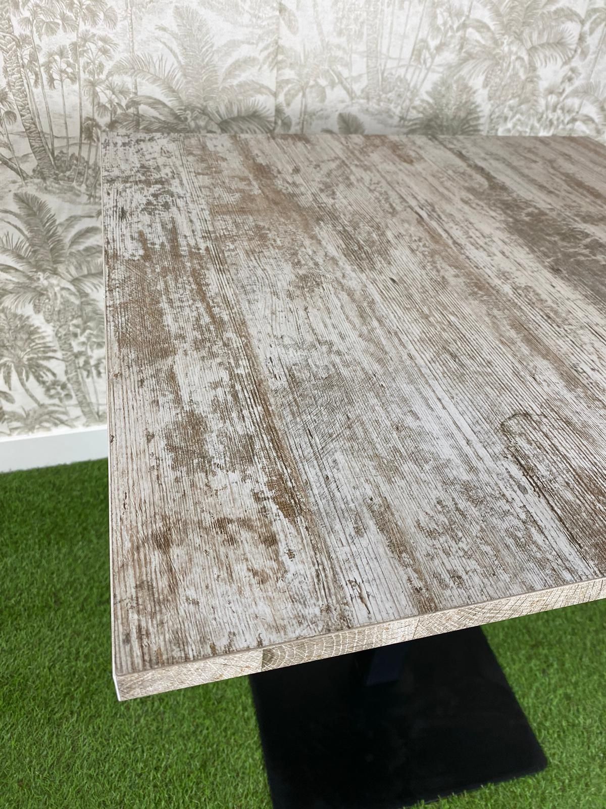 Una mesa de madera está colocada encima de una alfombra verde.