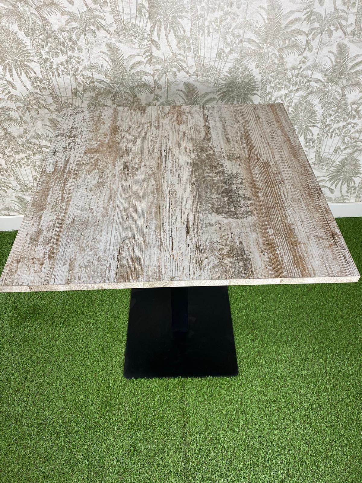 Una mesa de madera está colocada encima de una alfombra verde.