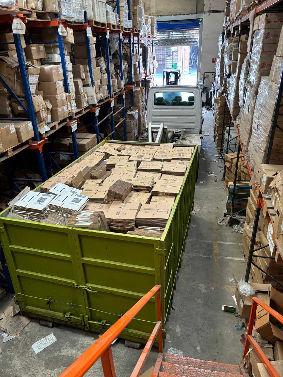 Persona con botas amarillas lavando a presión un patio de ladrillos al lado de un jardín.