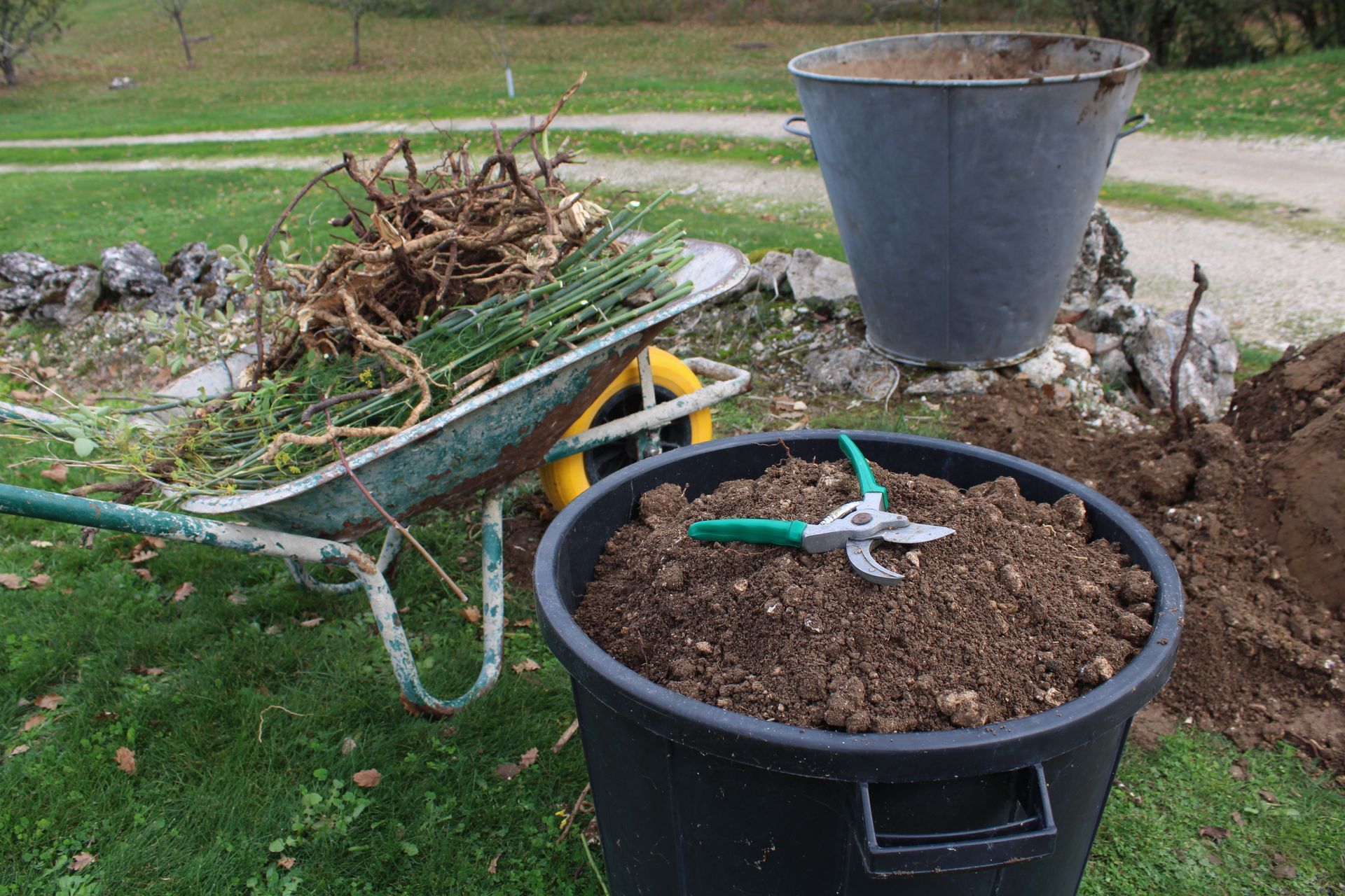 Outils de jardin et déchets de jardin dans une brouette.