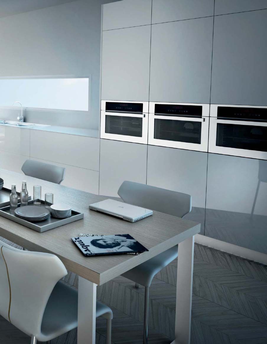 Una cocina con una mesa y sillas y una computadora portátil encima.