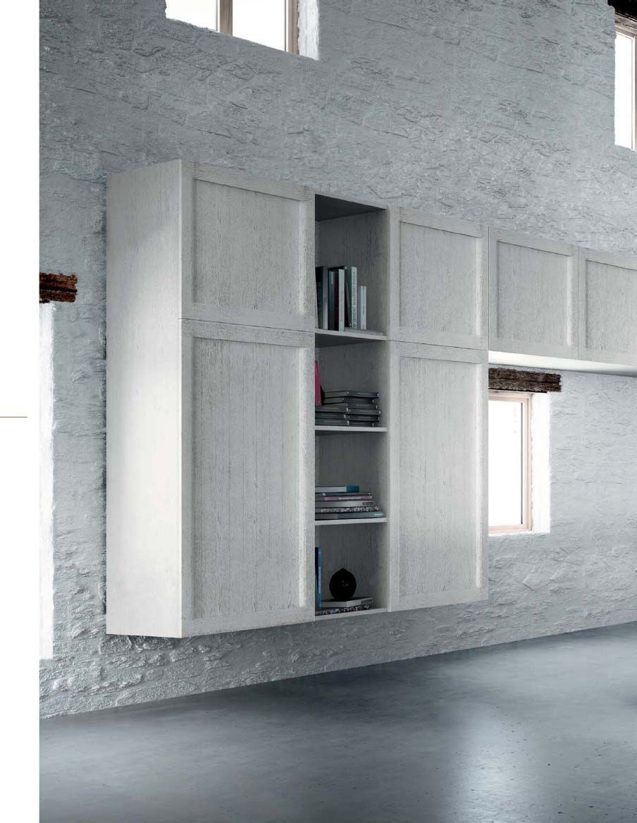 Una habitación con una pared de ladrillo y armarios y estantes blancos.