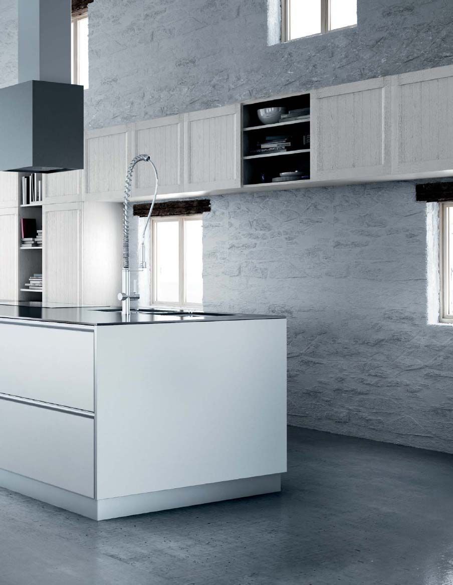 Una cocina con gabinetes blancos y una isla grande.