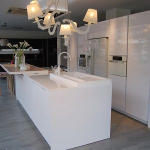 Una cocina con gabinetes blancos y una isla grande.