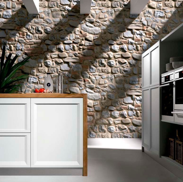 Una cocina con pared de piedra y gabinetes blancos.