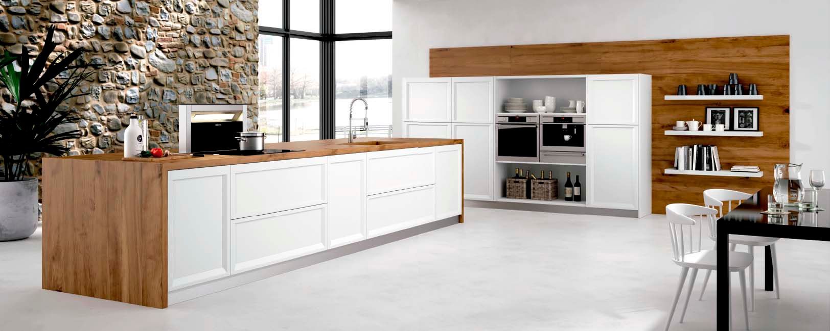 Una cocina con gabinetes blancos y una isla de madera.