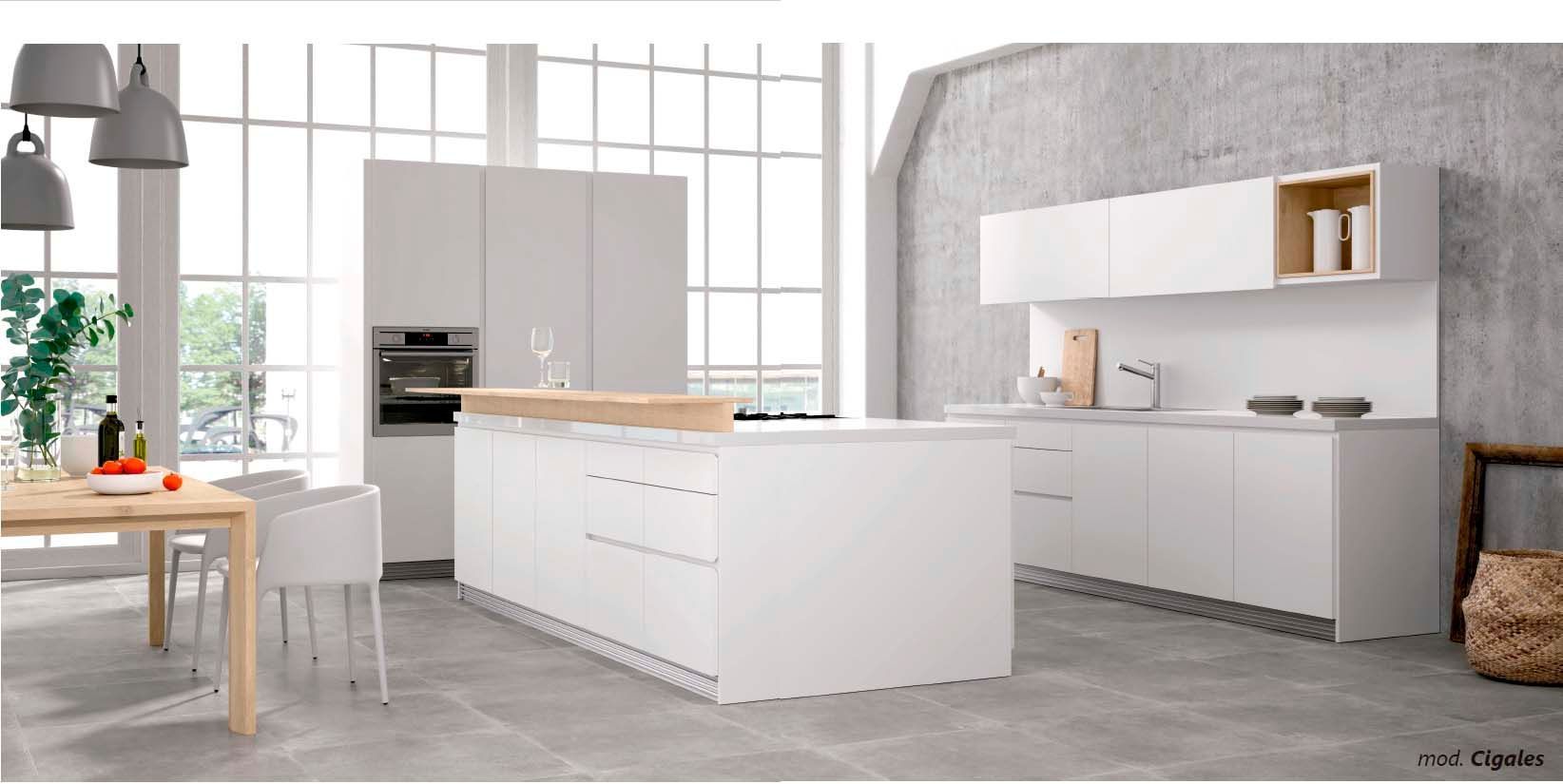 Una cocina con gabinetes blancos y una mesa de madera.