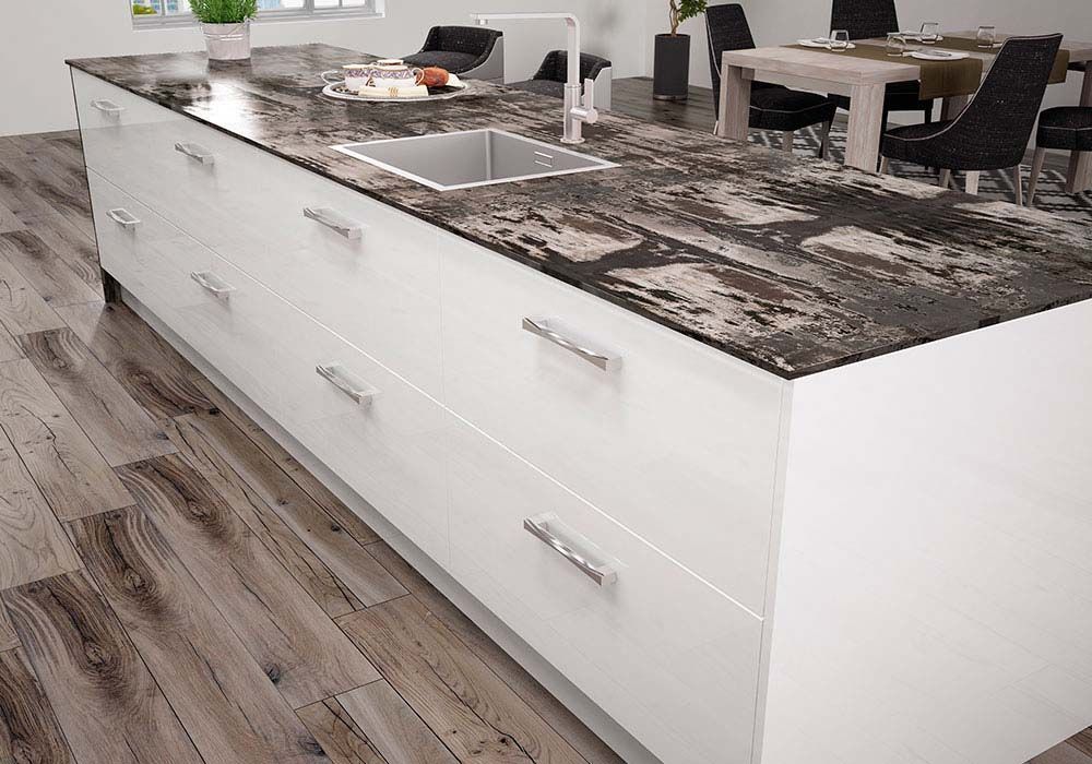 Una cocina con una gran isla con fregadero y cajones.