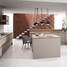 Una cocina con una gran isla y escaleras al fondo.