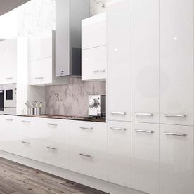 Una cocina con gabinetes blancos y piso de madera.