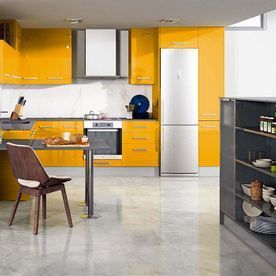 Una cocina con gabinetes amarillos, una mesa y sillas.