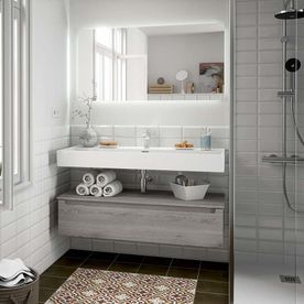 Un baño con lavabo, espejo y ducha.