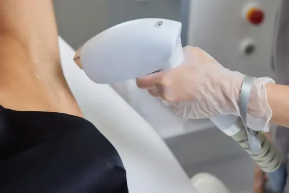 Pierna de una persona recibiendo tratamiento con un dispositivo de depilación láser.