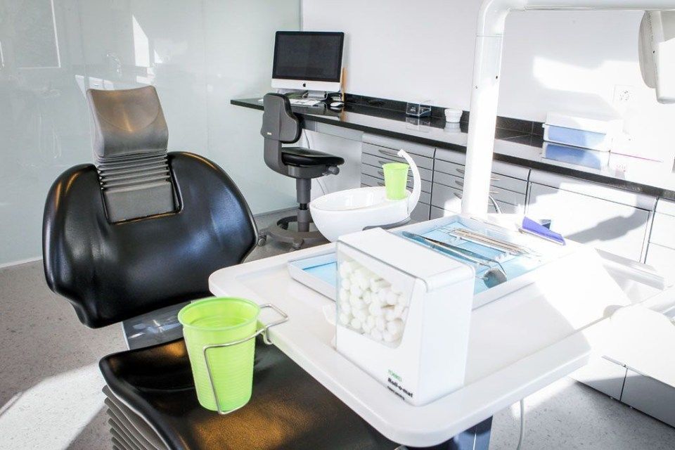 Zahnarzt: Behandlungsstuhl  mit Tablet und Wasserbecher