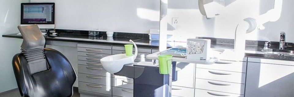 Zahnärztliches Behandlungszimmer mit Behandlungsstation, Wasserspender, Geräte und Wattespender