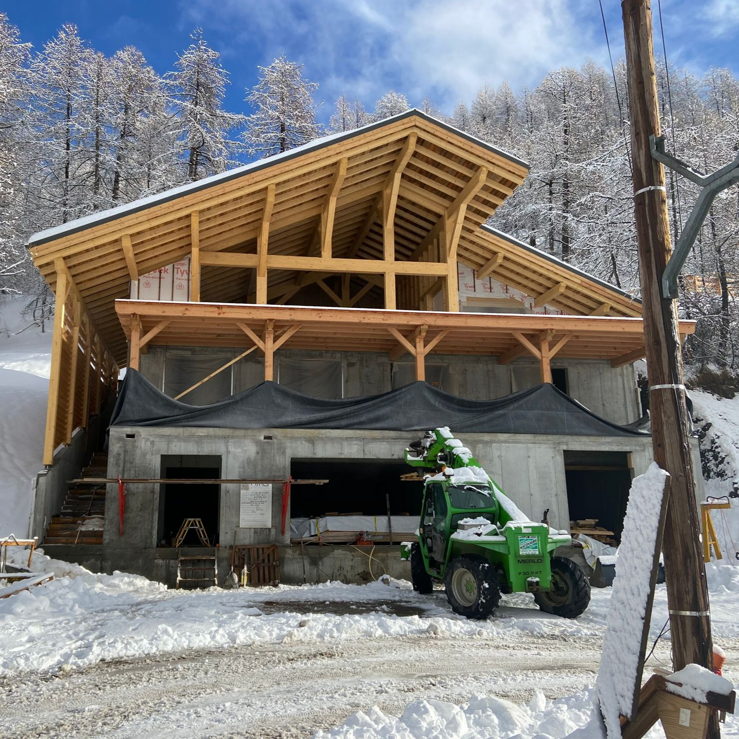 Un chantier de construction avec une structure à ossature bois et une base en béton