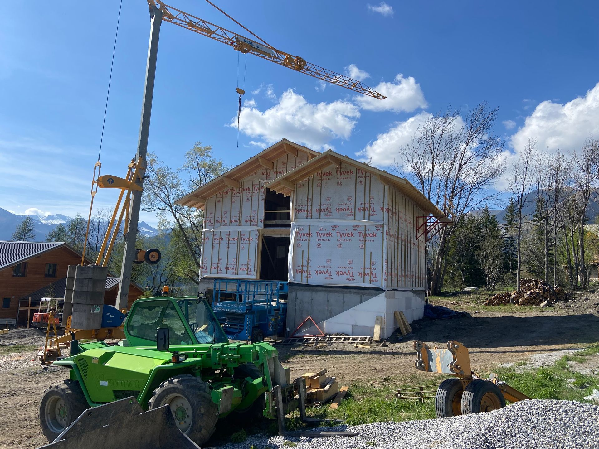 Un chantier de construction avec une maison en bois partiellement construite.