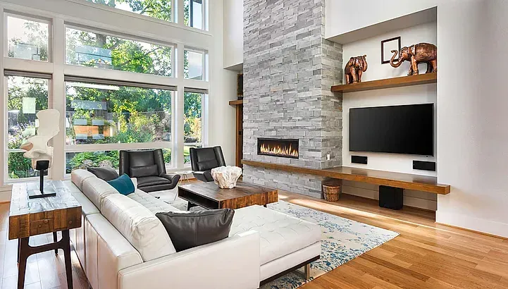 Una sala de estar con sofá, sillas, televisión y chimenea.