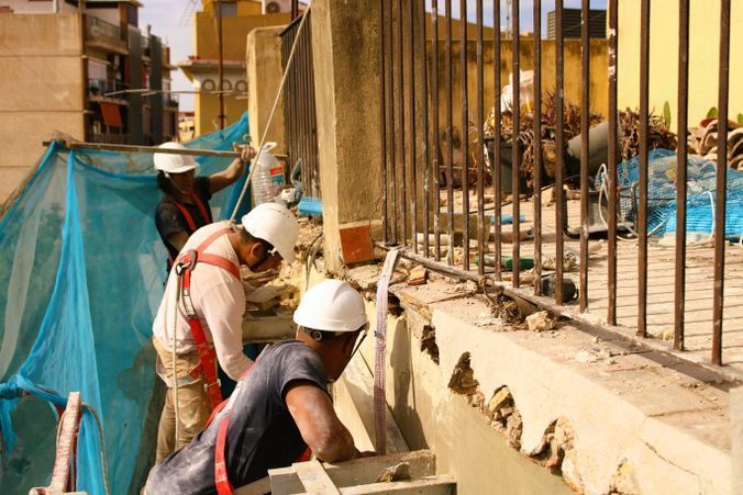 Un grupo de trabajadores de la construcción está trabajando en una valla.