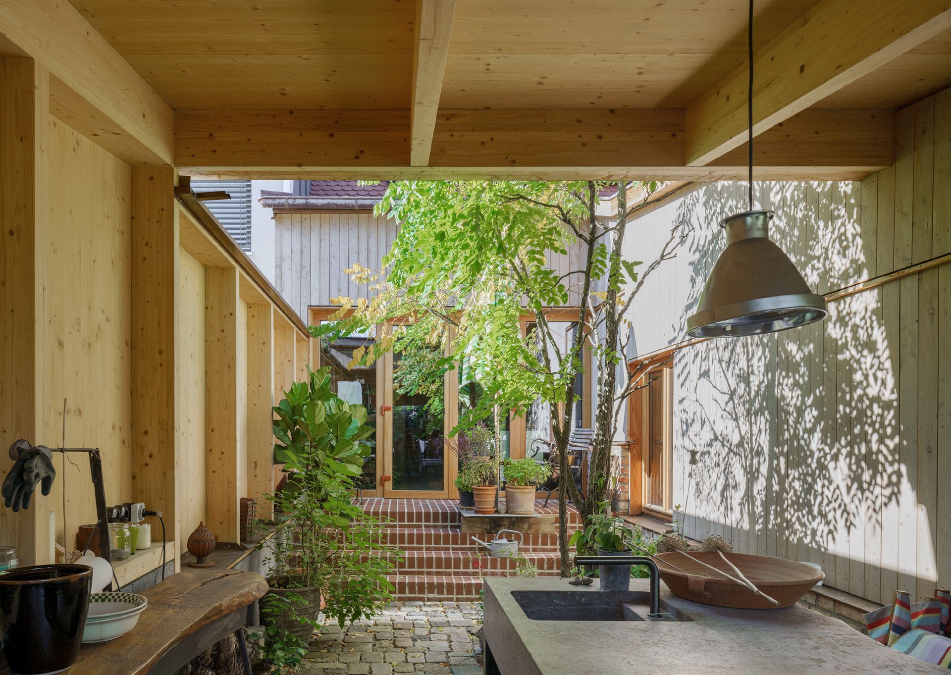 Innenhof des Haus Roth in Ingolstadt – lichtdurchfluteter Holzbau mit Pflanzen und moderner Architektur
