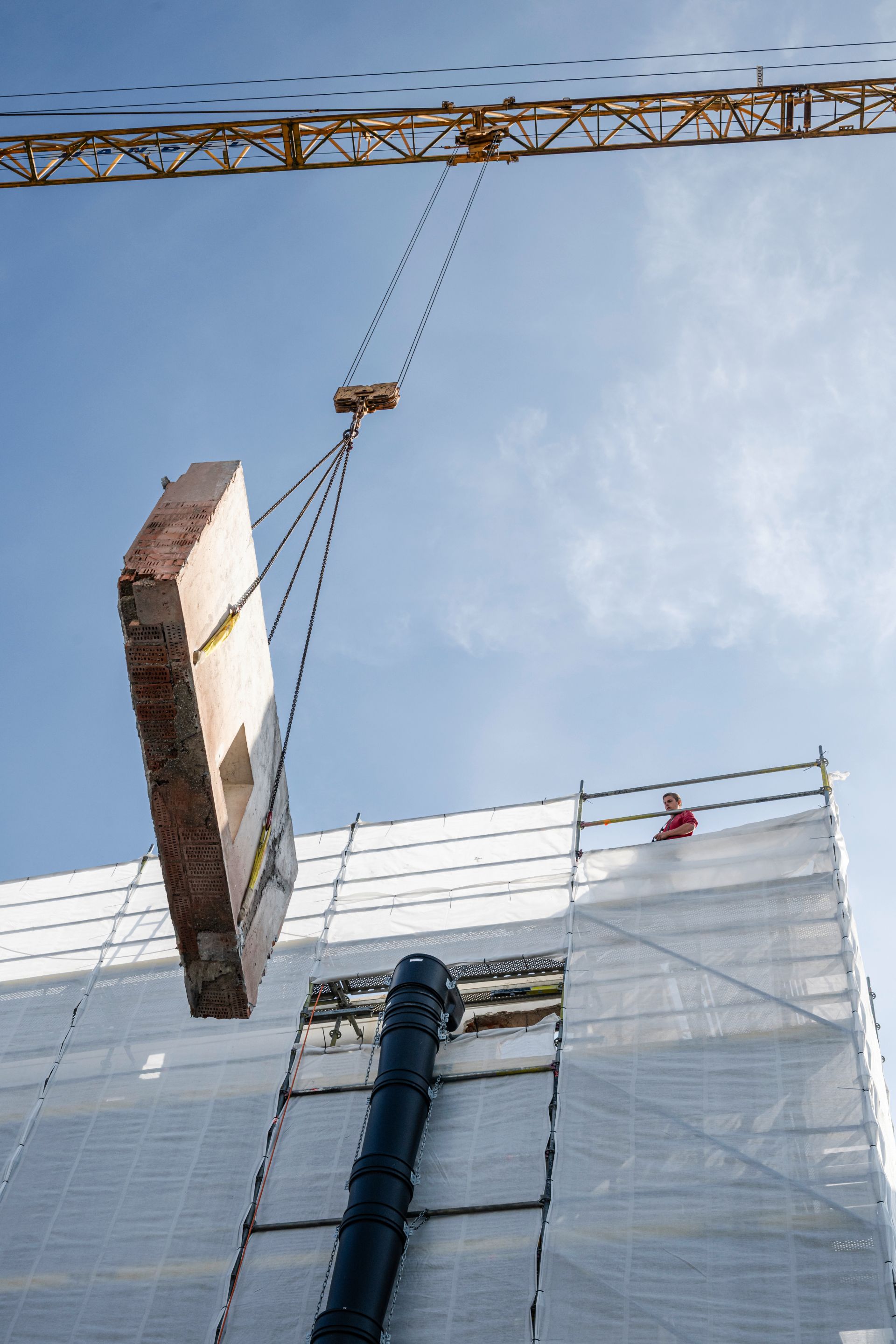 Betonplatte wird per Kran in Neubau eingehoben