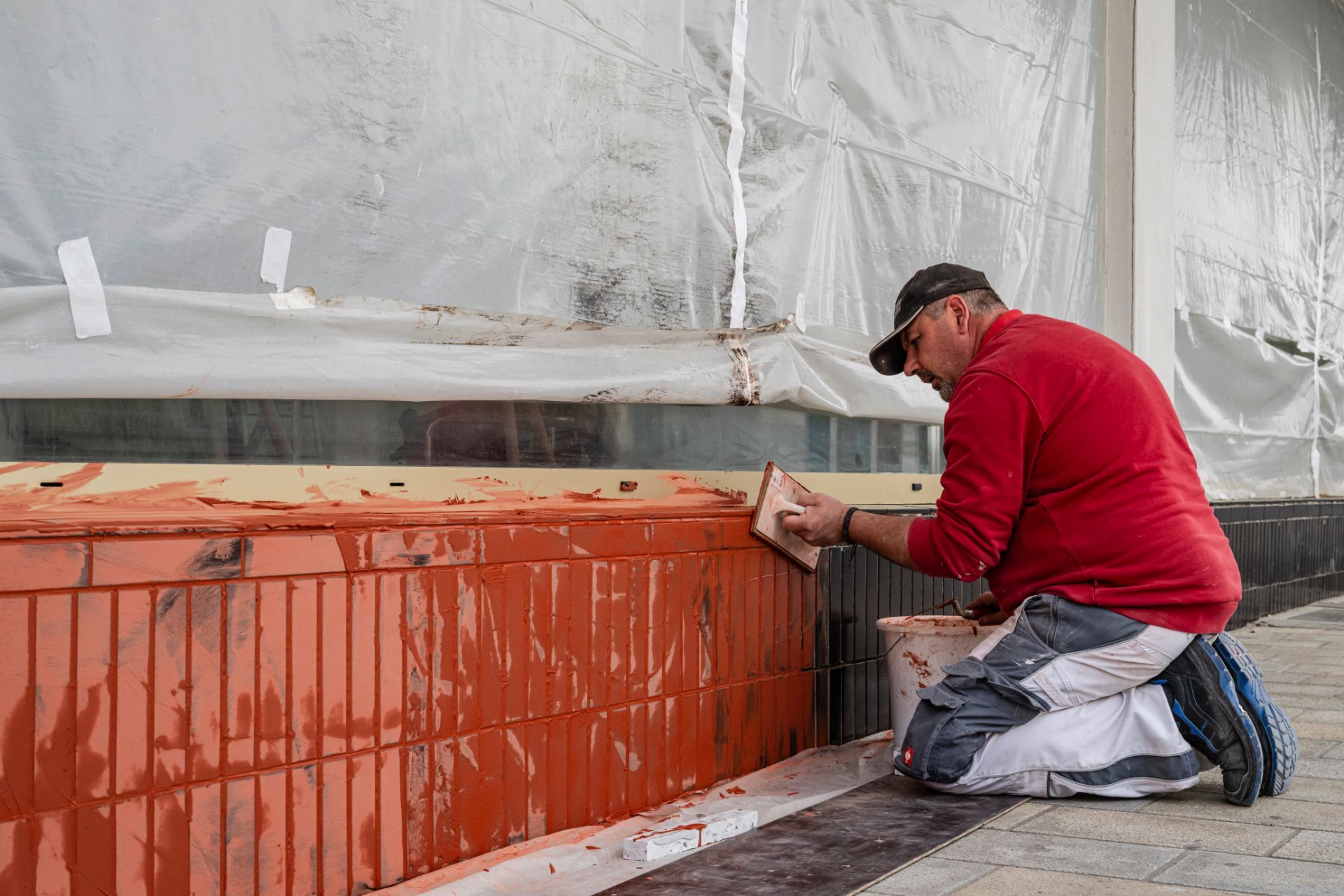 Fliesenarbeiten bei Gebäudesanierung an einer Fassade