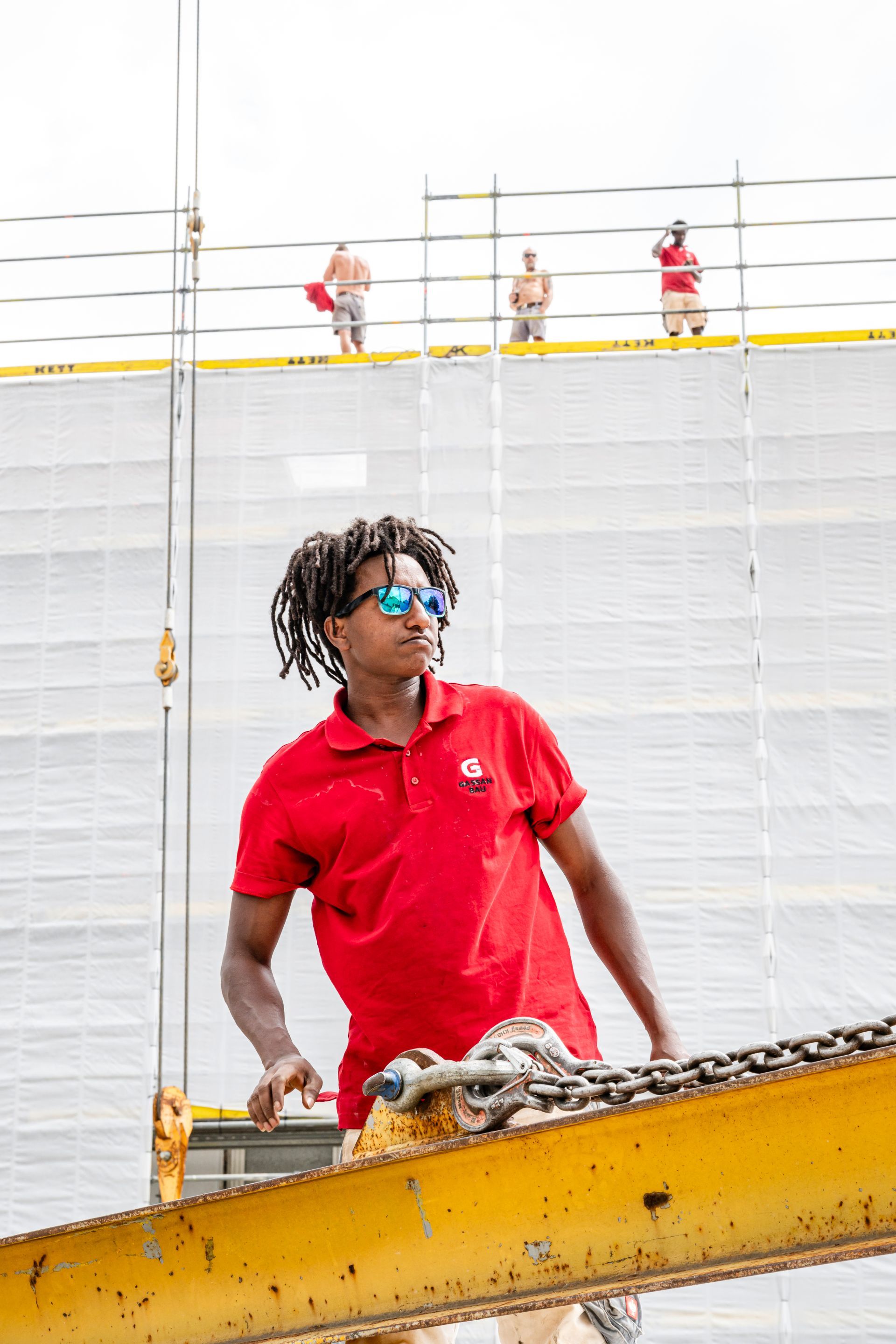 Bauarbeiter mit Werkzeug auf mehrgeschossiger Baustelle