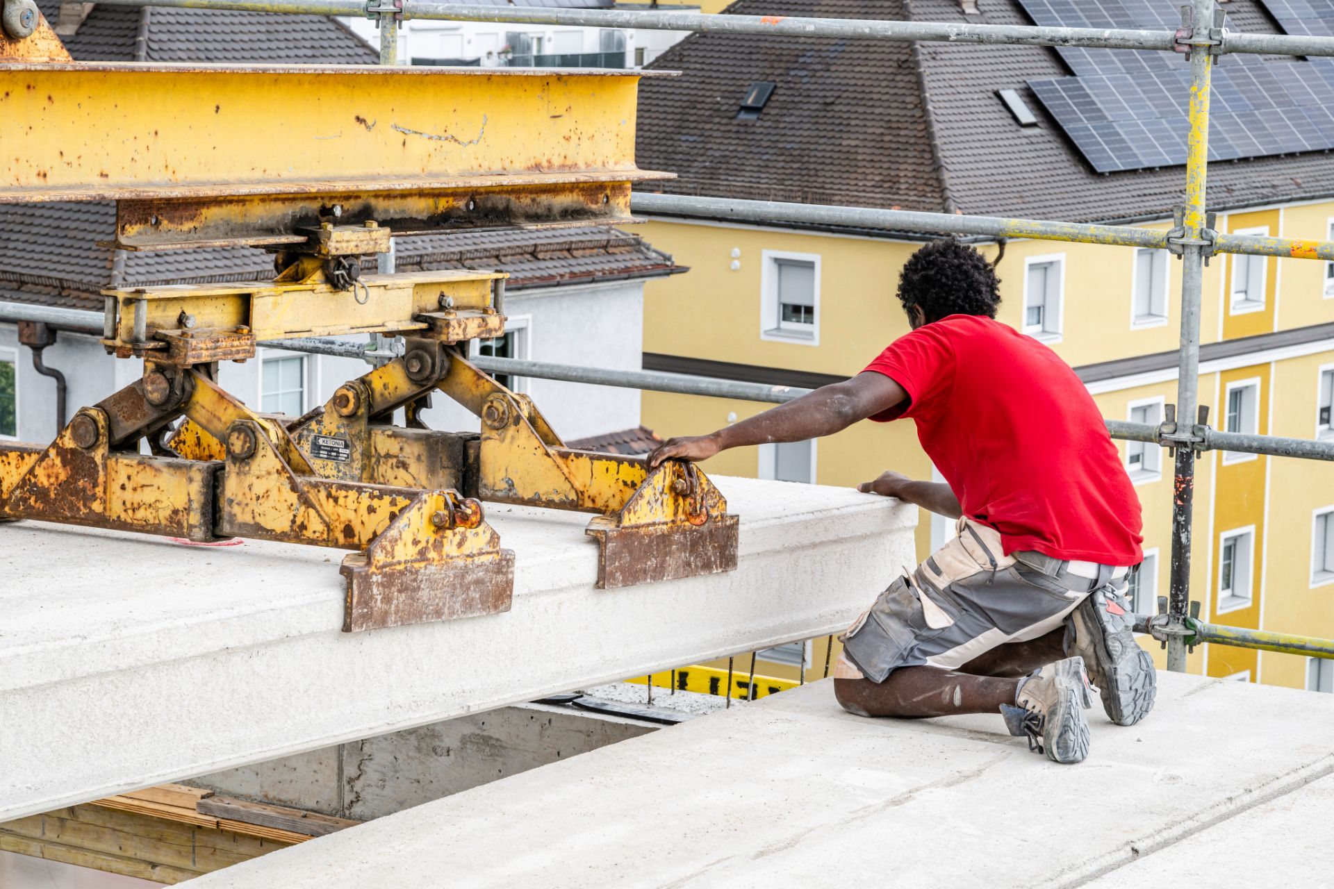 Hochbau mit Kran: Einheben von Betonwand in Neubau
