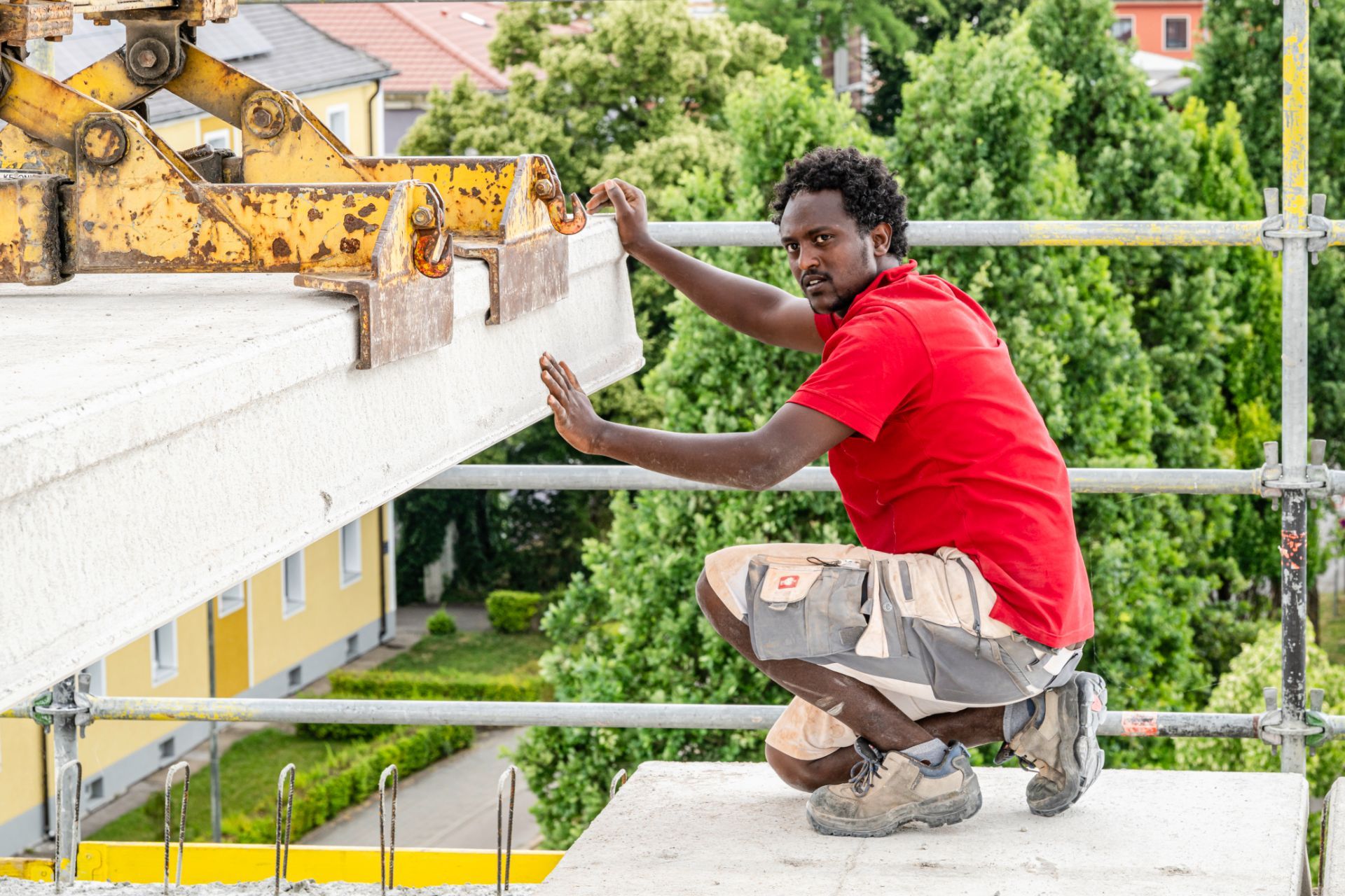 Arbeiter richtet schwere Betonplatte millimetergenau aus