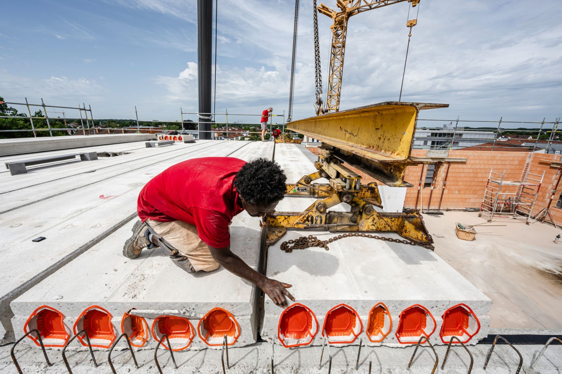 Handwerker führt Montage schwerer Betonelemente im Rohbau aus