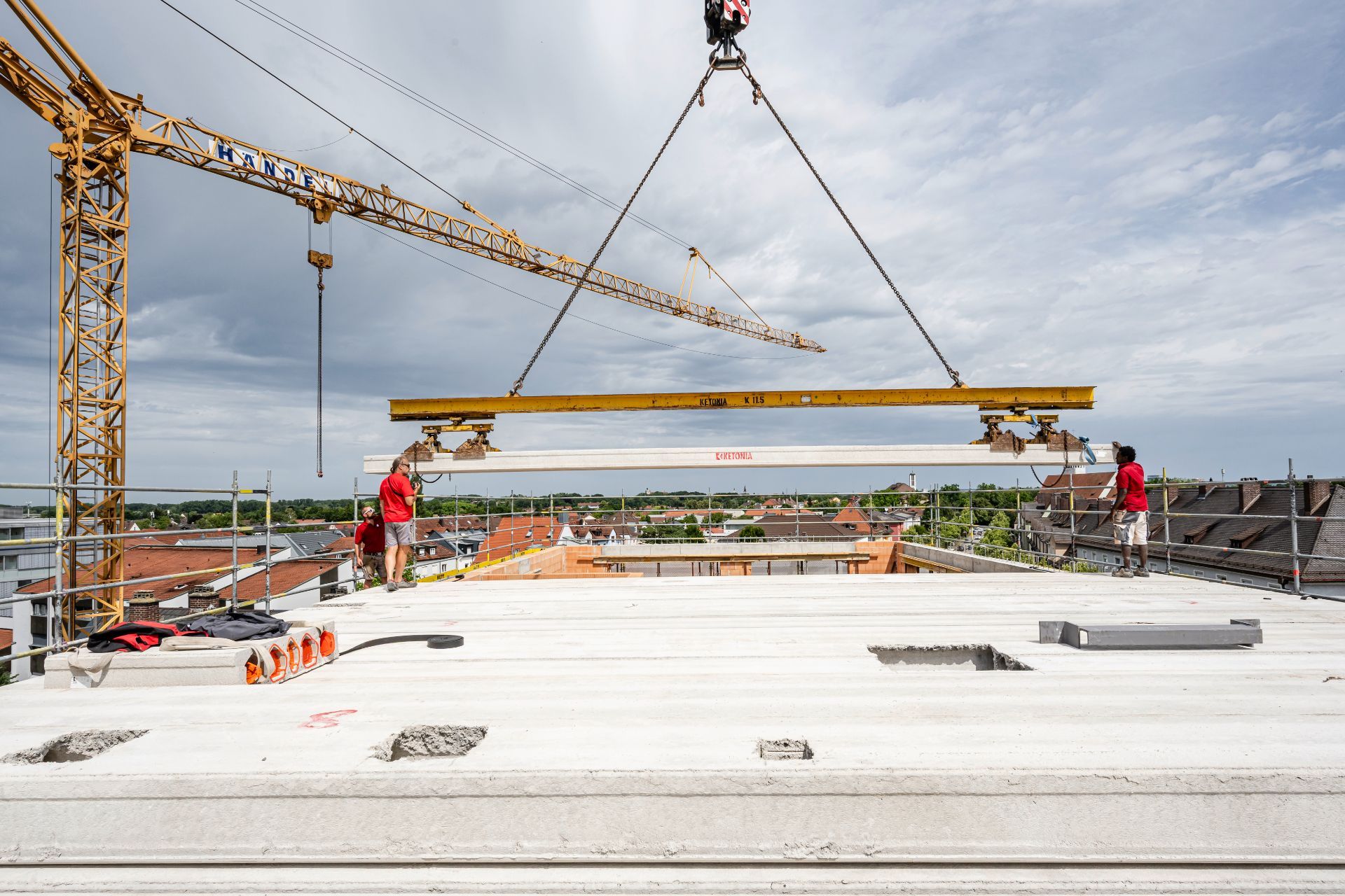 Großer Kran hebt Betonträger für Hochbau-Montage