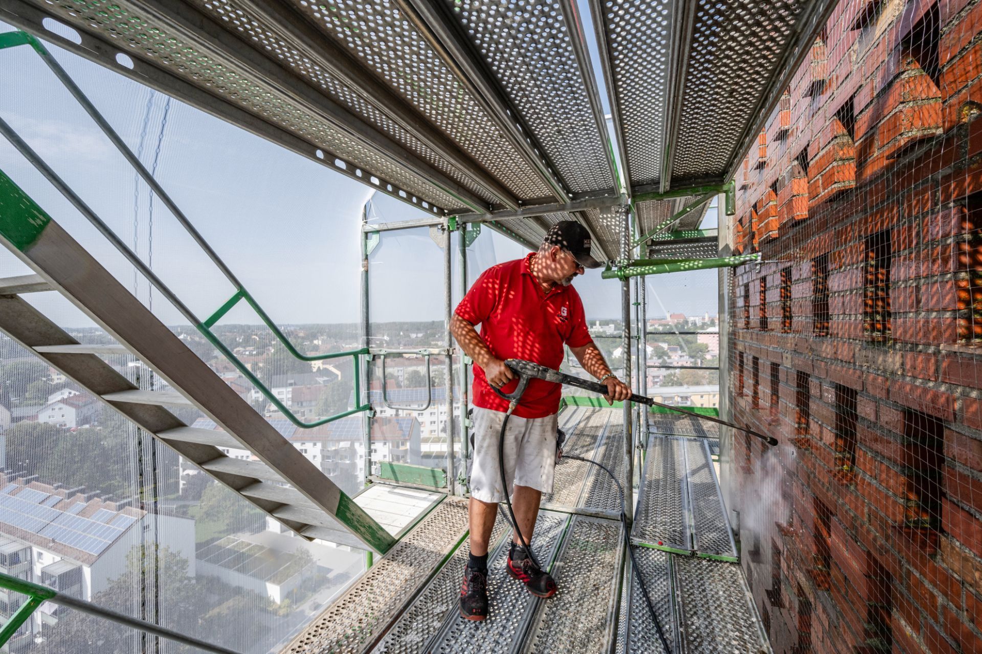 Arbeiter auf hohem Gerüst bei Fassadensanierung