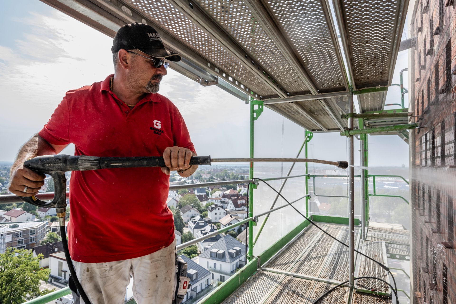 Bauarbeiter beim Arbeiten auf Gerüst über Stadtgebiet